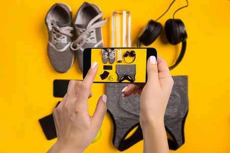 Sport equipment photographing on mobile phone. Smartphone screen with fitness tools image