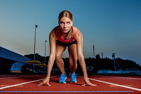 Portrait of beautiful woman ready to start running.の写真素材