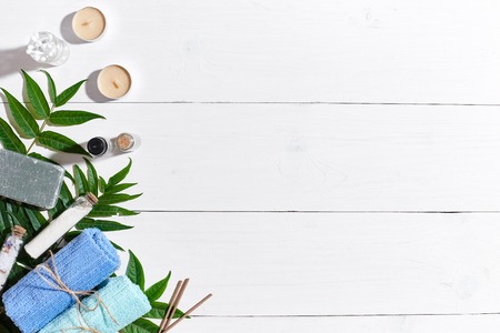 Spa set with towels and soap on white wooden background top viewの写真素材