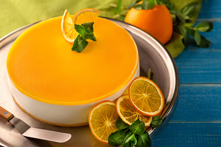 Orange Cake in white dish on the blue wood tableの写真素材