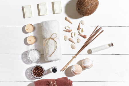Spa set with sea salt, essential oil, soap and towel decorated with seashells on white wooden backgroundの写真素材