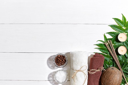 SPA still life with towel, candles and green leaves on a white wooden surfaceの写真素材