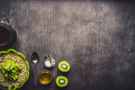 Healthy breakfast ingredients. Bowl of oat granola, fresh fruit and honey. Top view, copy space. Tonedの写真素材