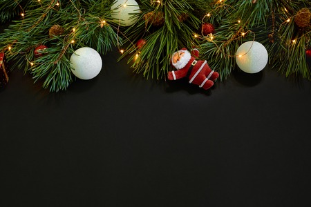 Christmas. Xmas toys and spruce branch on black background top view. Space for text