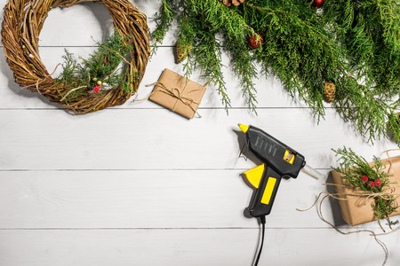 Make a Christmas wreath with your own hands. Spruce branch, Christmas wreath and gifts on a white wooden backgroundの写真素材