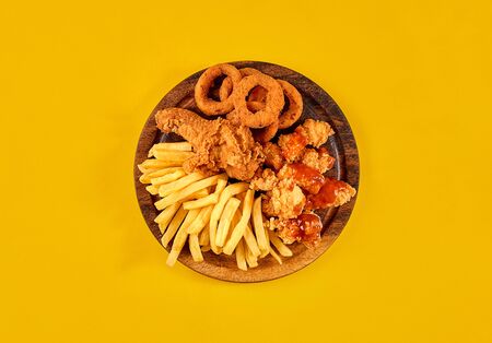 Fast food dish on yellow background. Fast food set fried chicken and french fries. Take away fast food.の写真素材