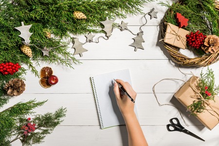 Juniper branches with a Christmas decor. Christmas, New Year background. Coniferous branches of juniper, notebook and a pen.の写真素材