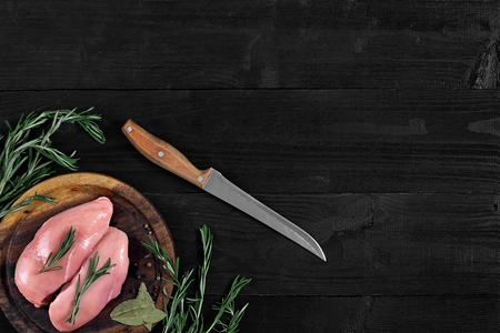 Raw chicken breast and condiments in a rustic wooden setting, top viewの写真素材