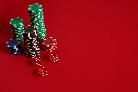 Poker chips on red background. Group of different poker chips. Casino background.の写真素材