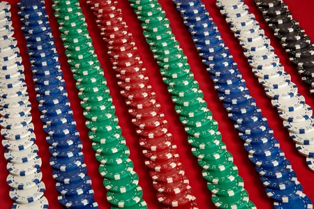 Stack of poker chips on red background at casinoの写真素材