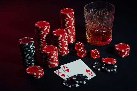Cards of poker player. On the table are chips and a glass of cocktail with whiskey. Cards - Ace and...