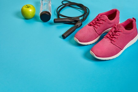 Flat lay of dumbbell, bottle of water, jump rope and sneaker, sport equipments, fitness items, top...