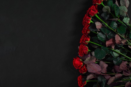 Bouquet of red roses on a black background. Top view. Flat lay. Copy space. Still lifeの写真素材