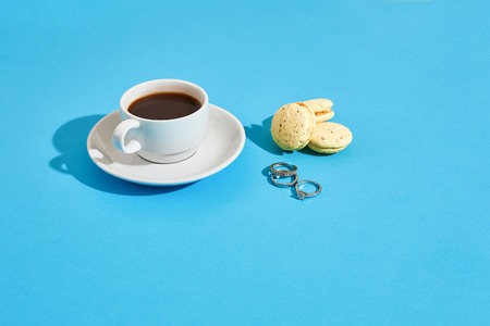 Tasty sweet macarons and coffee cup. Macaroons on blue background. Top view. Still life. Copy space. Flat lay. Valentine's day greeting cardの写真素材