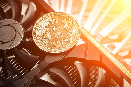 The coin of bitcoin lies on video card with dollars. Exchange bitcoin cash for a dollar. Sun flareの写真素材