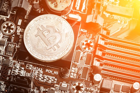 Bitcoin. New virtual money. Bitcoins lie on the video card, concept of mining. Sun flareの写真素材