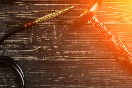 Dismantled parts of hookah on wooden background. Sun flareの写真素材