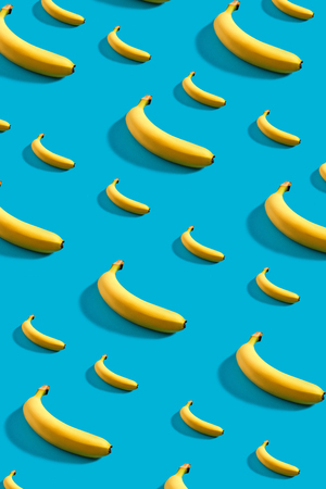 Colorful pattern of bananas on sky blue background.の写真素材