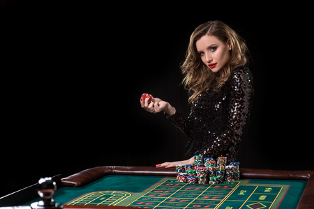 Woman playing in casino. Woman stakes piles of chips playing rouletteの写真素材