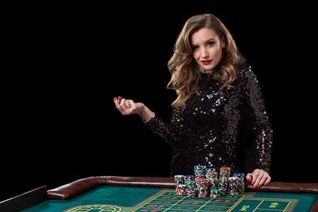Woman playing in casino. Woman stakes piles of chips playing rouletteの写真素材