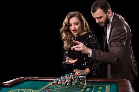 Man and woman playing at roulette table in casinoの写真素材