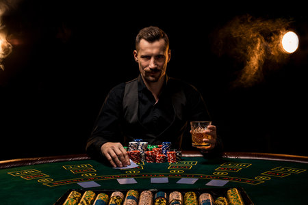 Poker player. Young guy in the casino at the gaming table. Man gambling, card games. Cards, chips, whiskey, cigarettes, poker, card game, gambling - gambling concept.の写真素材