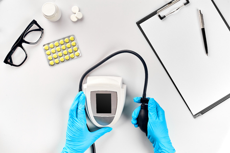White electric tonometer on white table for measuring blood pressure with stethoscope. Measurement of pressure and pulse.の写真素材