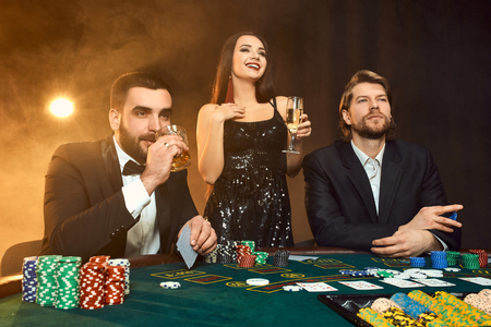 Group of young rich people is playing poker in the casinoの写真素材