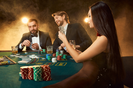 Group of young rich people is playing poker in the casinoの写真素材