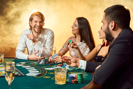 Upper class friends gambling in a casino.の写真素材