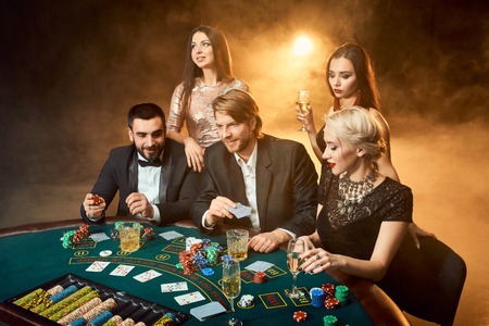Poker players sitting around a table at a casino.の写真素材