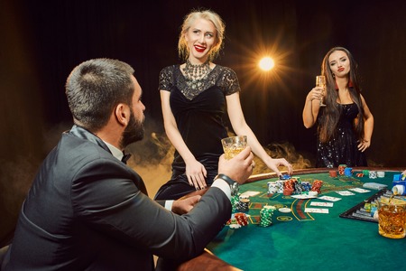Group of young rich people is playing poker in the casinoの写真素材