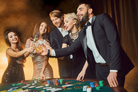 Group of happy people during celebration is drinking sparkling wine in the casinoの写真素材