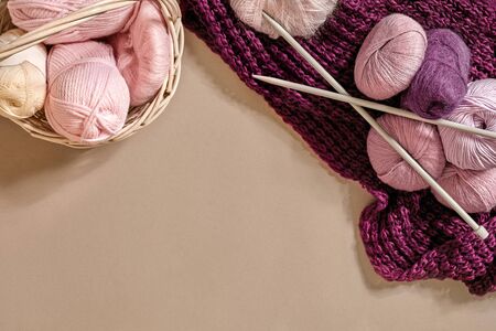 Yarn balls. Balls of colored yarn in a wicker dish. Yarn for knitting on a beige background....
