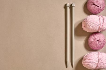 A group of colored balls of yarn and knitting needles on a beige background. Top view. Still life. Copy space. Flat layの写真素材