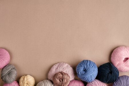 Set of colorful wool yarn on beige background. Knitting as a kind of needlework. Colorful balls of...