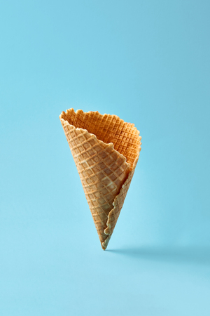 Waffle cornet on light blue background.の写真素材