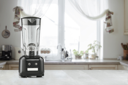 Blender and wooden table in kitchenの写真素材