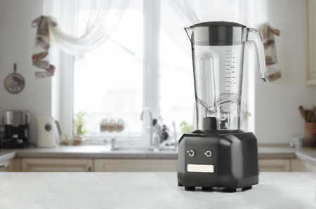 Blender and wooden table in kitchenの写真素材