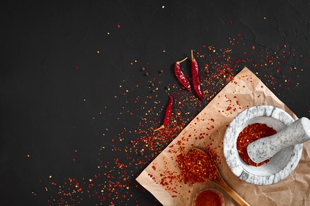 Dried and crushed red chili pepper in stone mortar. Copy spaceの写真素材