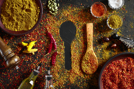 Assorted spices on dark black background. Seasonings for food. Curry, paprika, pepper, cardamom, turmeric. Top view. Close-up. Spices concept. Spices ingredients for cookingの写真素材