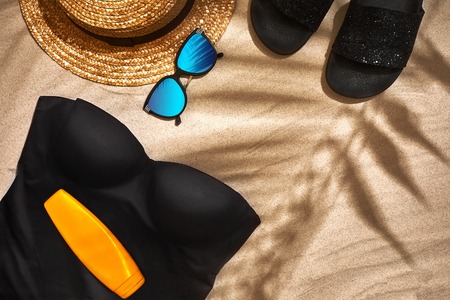 Summer background with straw hat, sunglasses, sunscreen bottle and flip flops. Top view. Still life....
