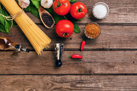 Pasta and ingredients on wooden background with copy space. Top view. Vegetarian food, healthy or cooking concept. Still life. Flat layの写真素材
