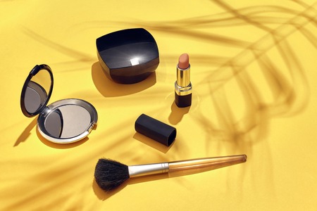 Woman's accessories lying flat on paper background. Yellow pastel colors with copy space around products. Horizontal image or photograph. Still lifeの写真素材