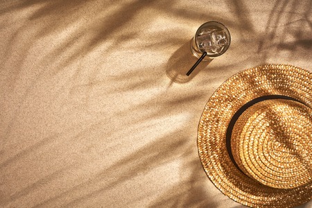 Top view of summer accessories on sandy beach. Shadow from a palm leaf. Still life. Copy space. Flat layの写真素材