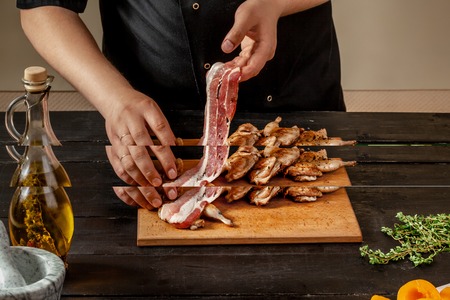 Preparing quail specialty, rolling quail with baconの写真素材