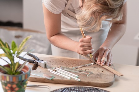 Workplace of the mosaic master: womens hands holding tool for mosaic details in the process of making a mosaicの写真素材
