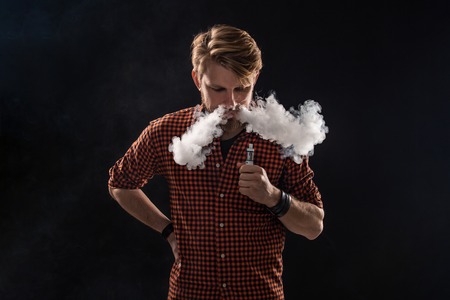 A young man with a beard and a stylish hairstyle in a shirt, smoking a cigarette, a viper, a room, a...