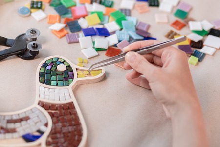 Hands of master working on new modern colorful mosaic. Close-upの写真素材