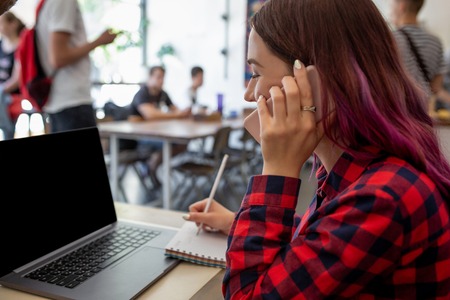 Woman typing on notebook with blank screen with copy space for your text or advertising content, sitting at wooden tableの写真素材